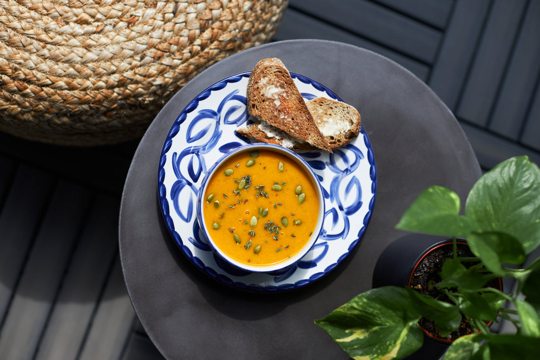 Soup on a blue and white plate with crusty bread