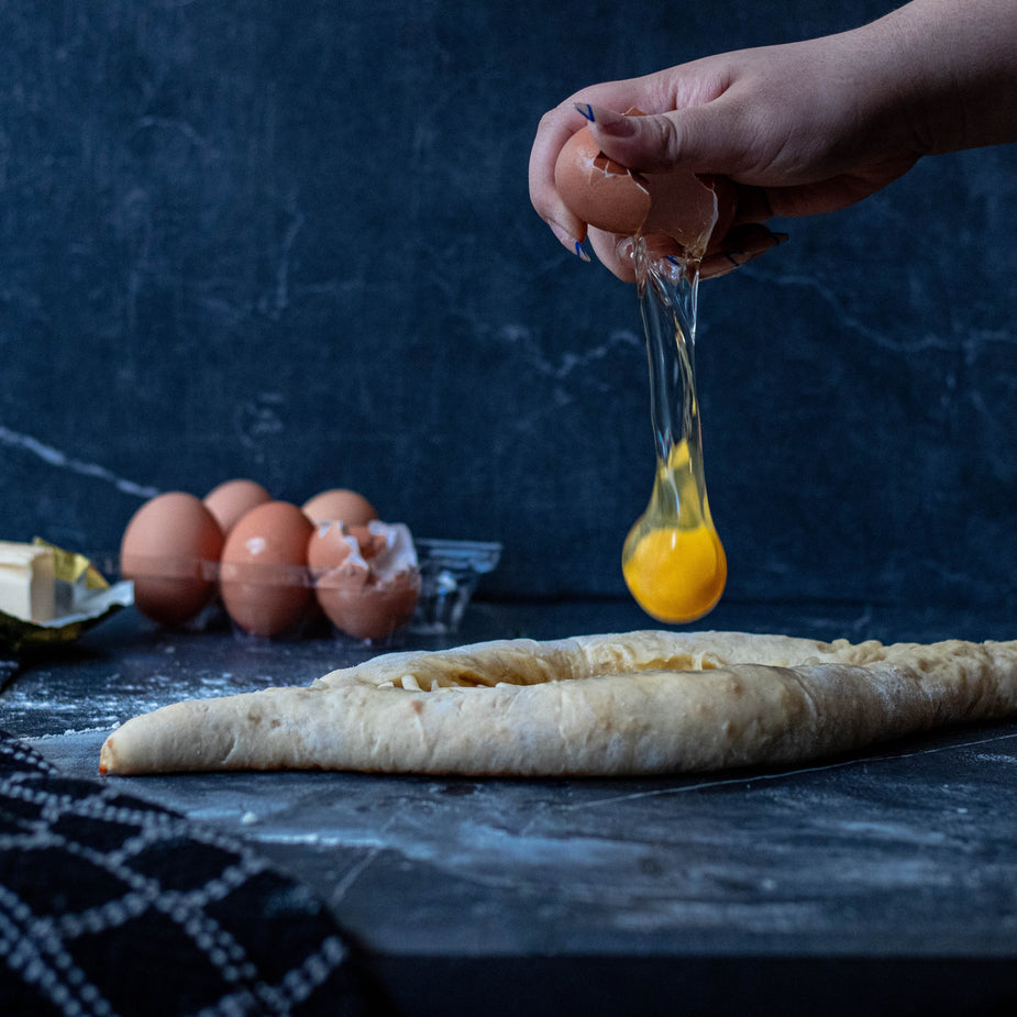 Fresh egg on dough on a marble surface