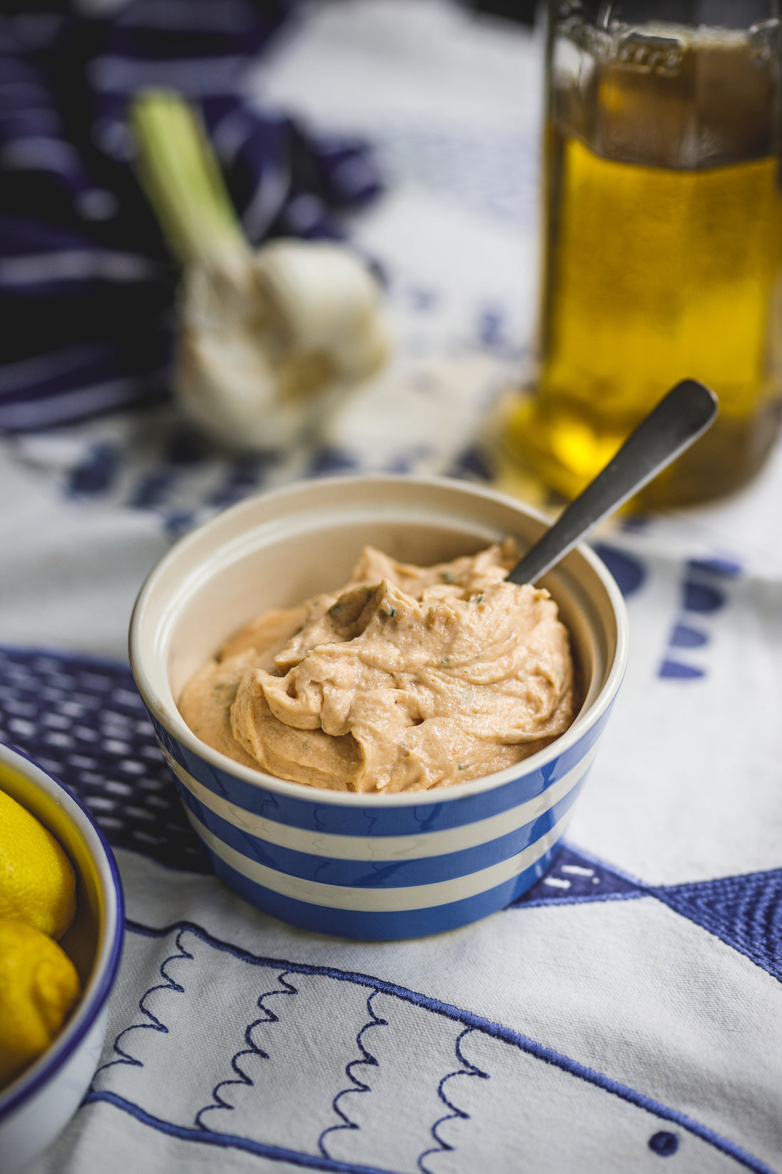 Homemade Hummus in a blue and white bowl with Hawaij spice