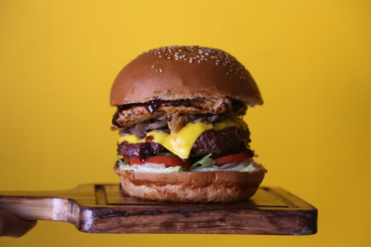 Burger on wooden board and yellow background